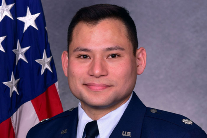 Erik Lin-Greenberg in uniform portrait with flag